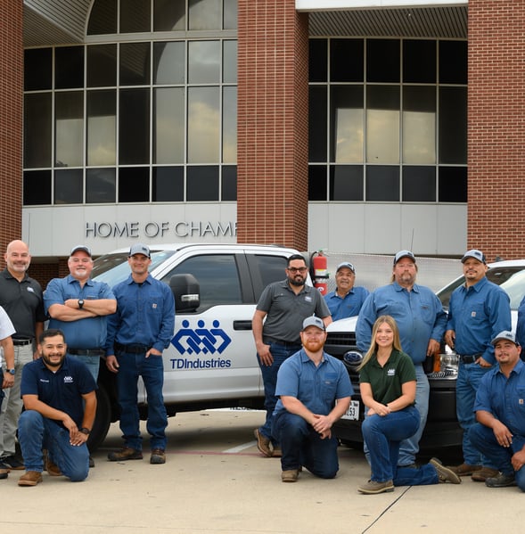 Maintenance, facilities and EHS professionals pose in front of TD truck at a high school