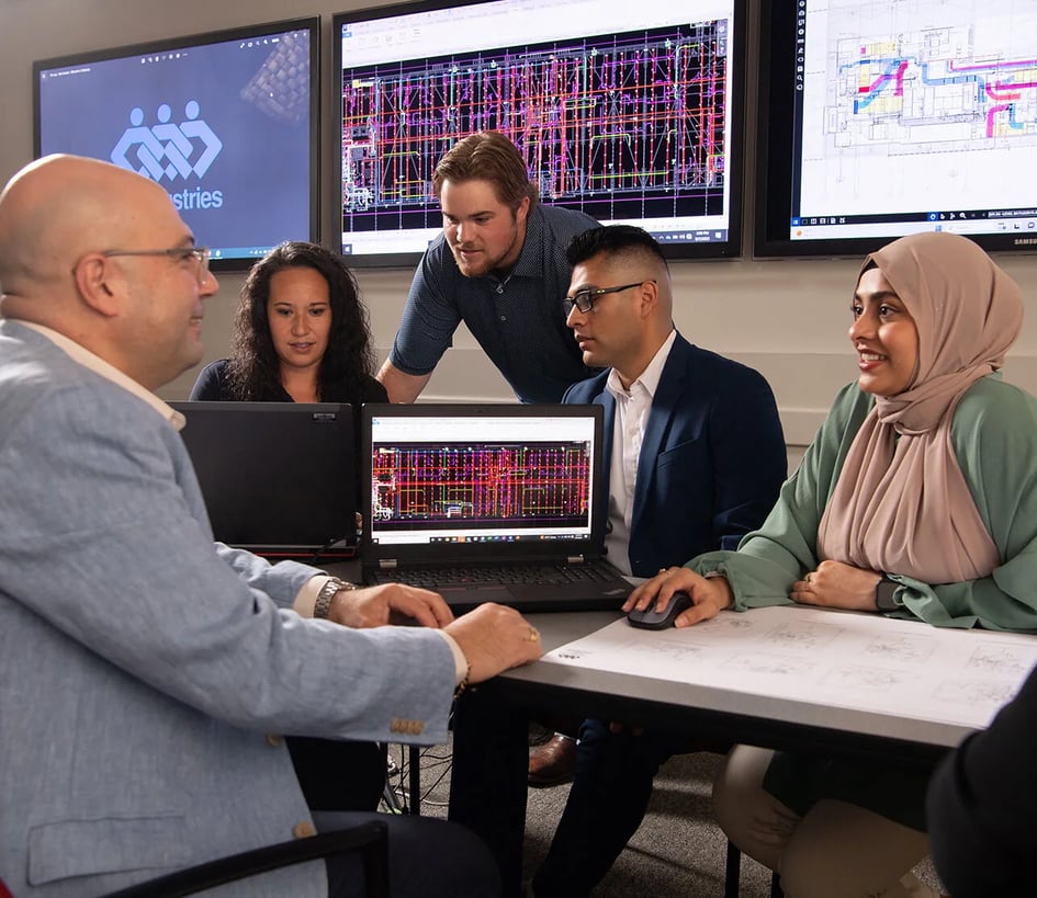Diverse team of engineers meets to review BIM plans for a construction project